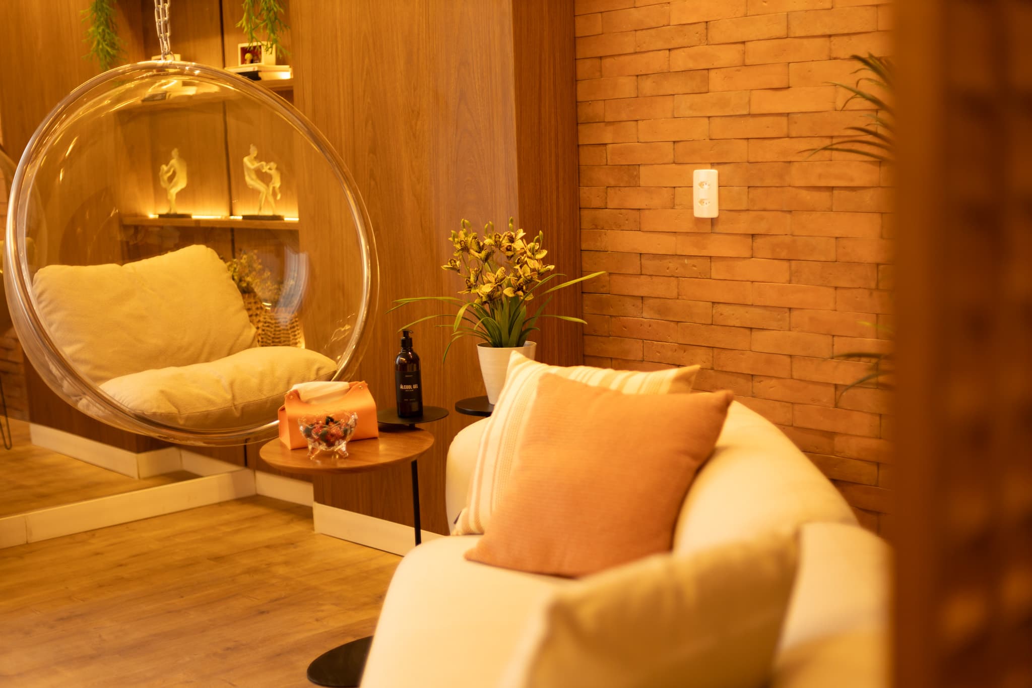 Sala de atendimento presencial com poltrona, cadeira suspensa e iluminação acolhedora